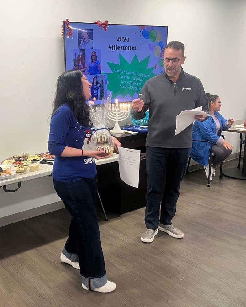 A Peeless employee receiving an award at the company's December office holiday lunch gathering.