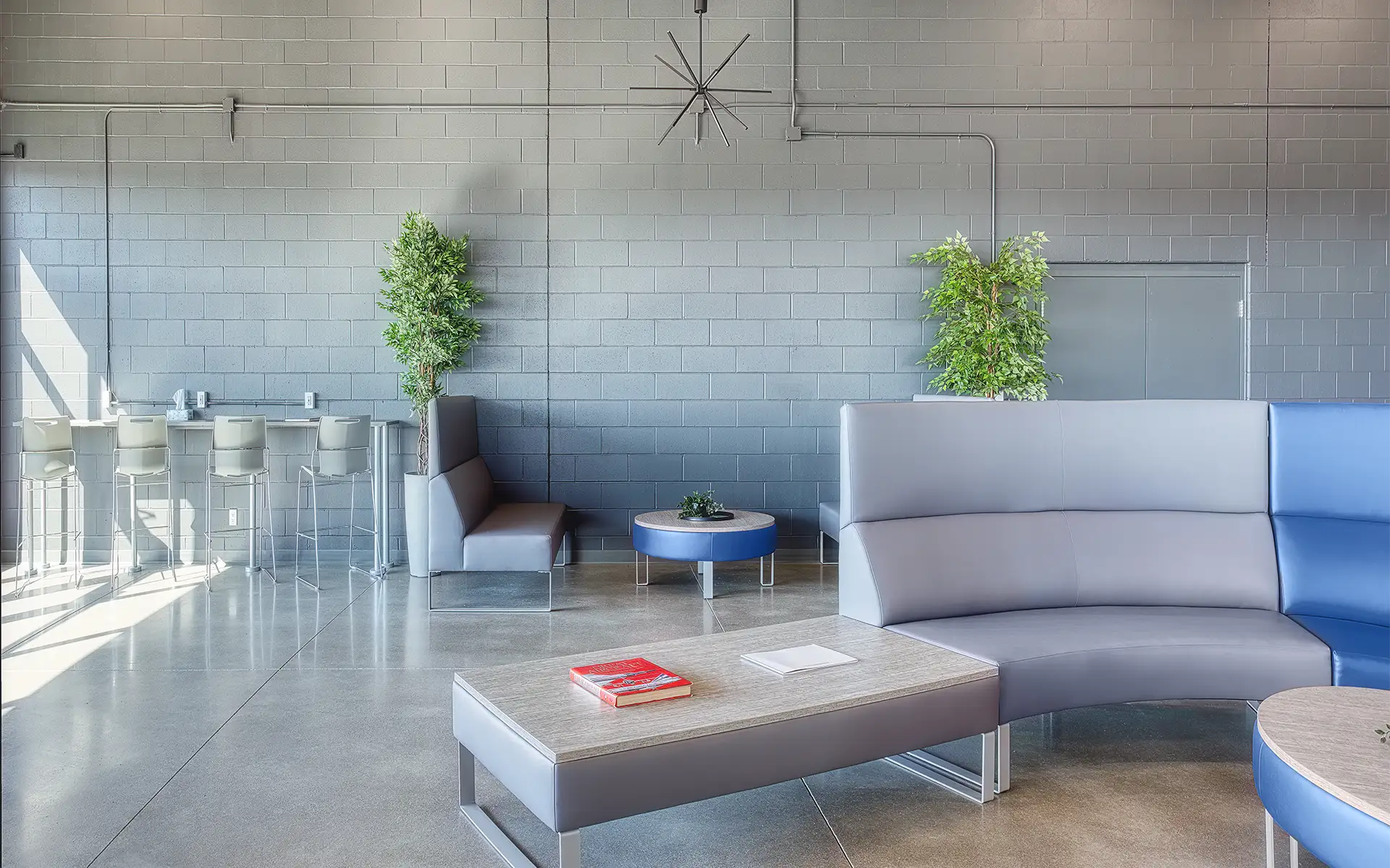 A Fixed Base Operator passenger and crew lounge featuring a modern, industrial design and a variety of seating options