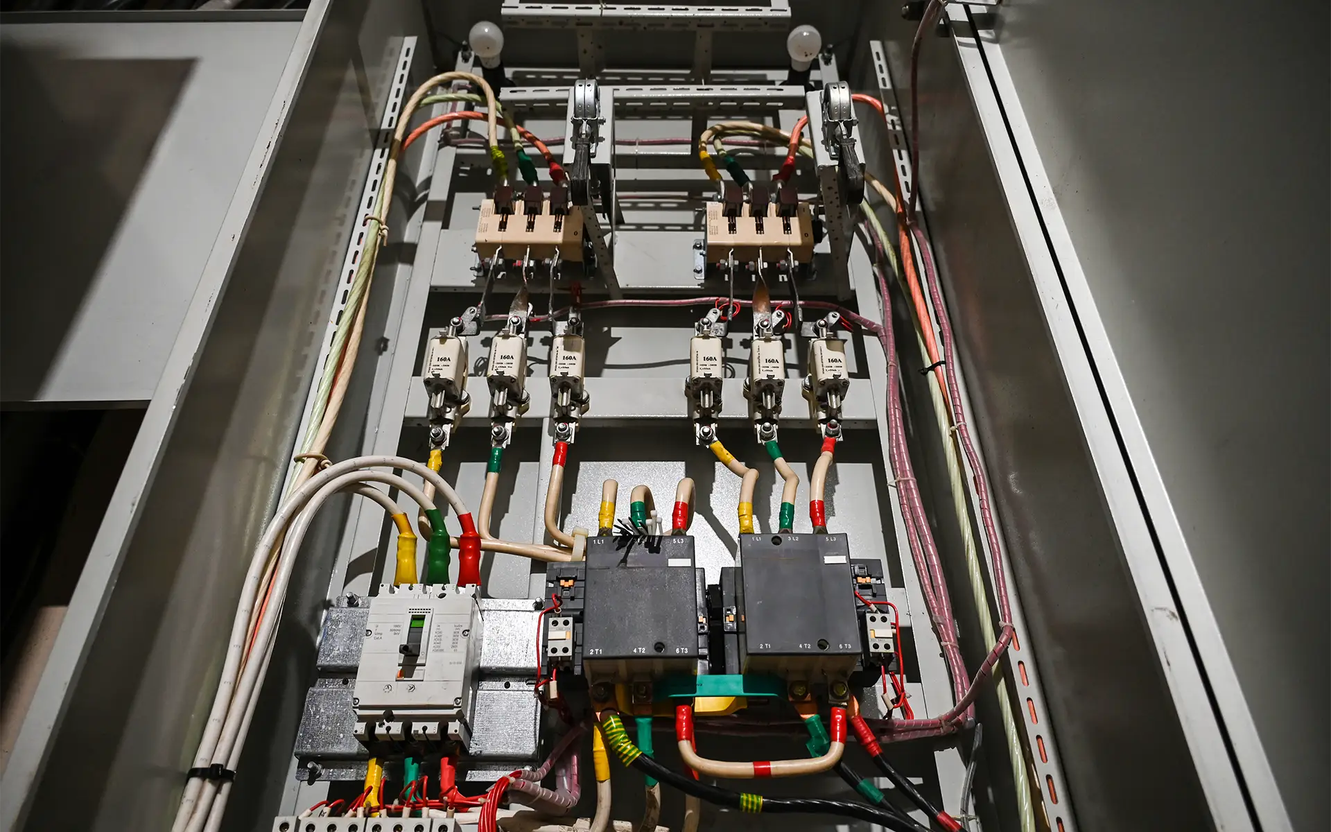 View of the interior of an industrial electrical control panel featuring contactors and wiring